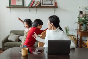 Mother distracted by children while working remotely